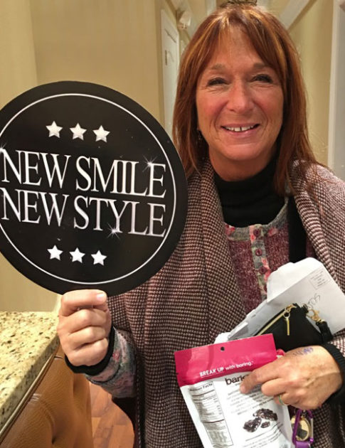 patient holding up new smile new style sign