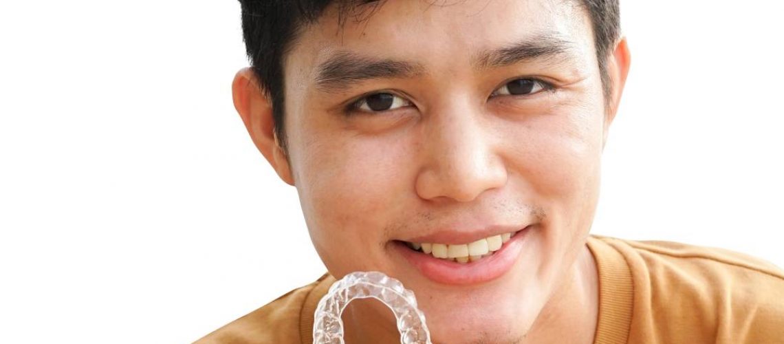 young man holding invisalign tray